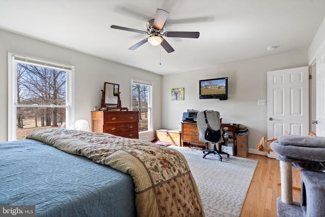 bedroom with light wood-type flooring, baseboards, and ceiling fan