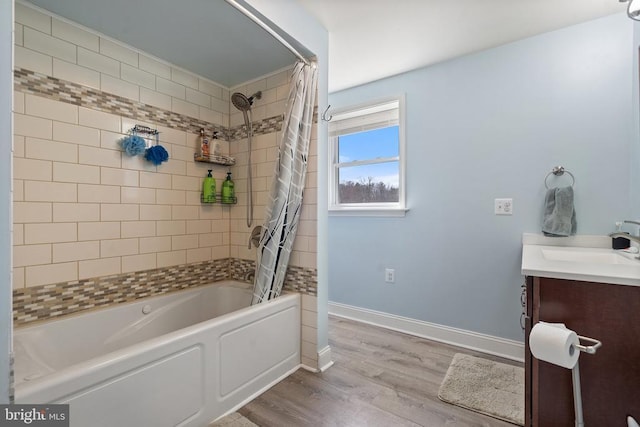 bathroom with vanity, shower / bath combo with shower curtain, wood finished floors, and baseboards