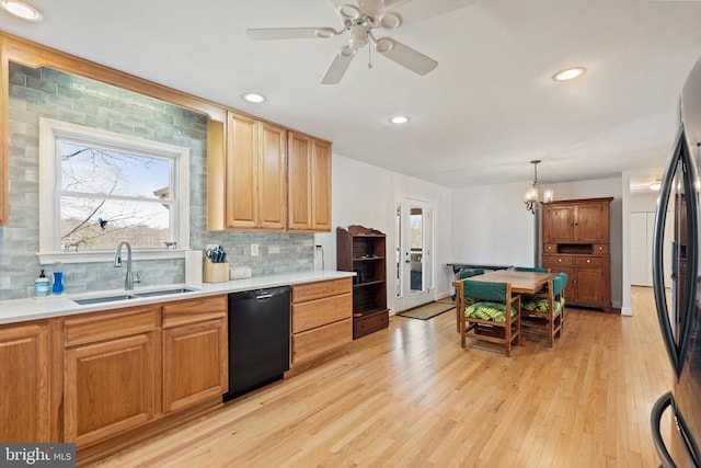 kitchen with light wood-style flooring, freestanding refrigerator, a sink, dishwasher, and backsplash