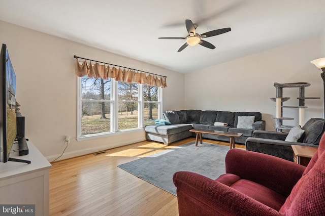 living room featuring ceiling fan, wood finished floors, visible vents, and baseboards