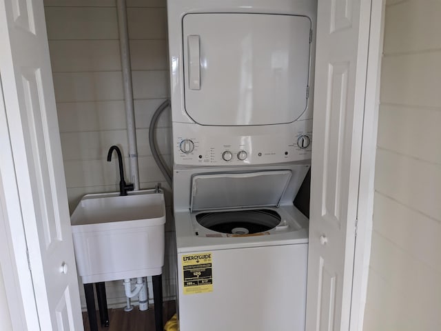 laundry area with stacked washer and clothes dryer and sink