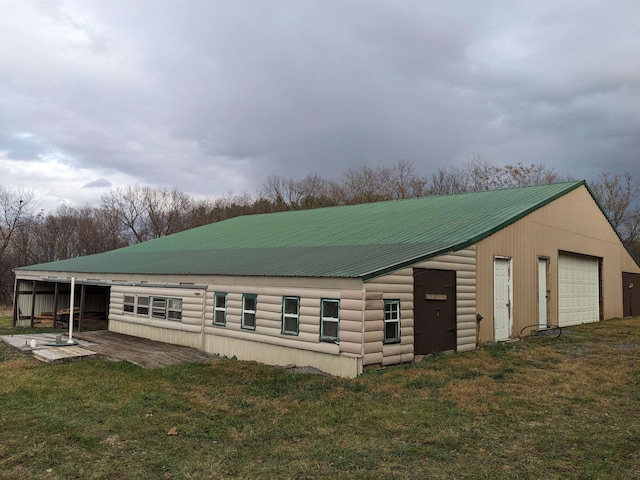 view of property exterior with a garage, an outbuilding, and a lawn