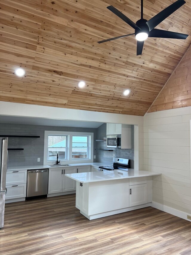 kitchen featuring white cabinets, light hardwood / wood-style floors, kitchen peninsula, stainless steel appliances, and wooden ceiling