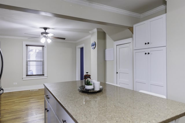 kitchen featuring ceiling fan, ornamental molding, light hardwood / wood-style flooring, and white cabinets