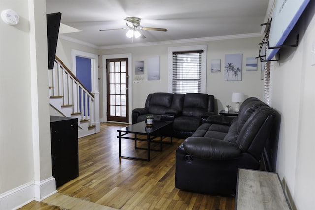 living room with wood-type flooring, ornamental molding, and ceiling fan