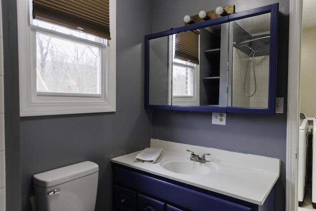 bathroom with vanity, a shower, and toilet