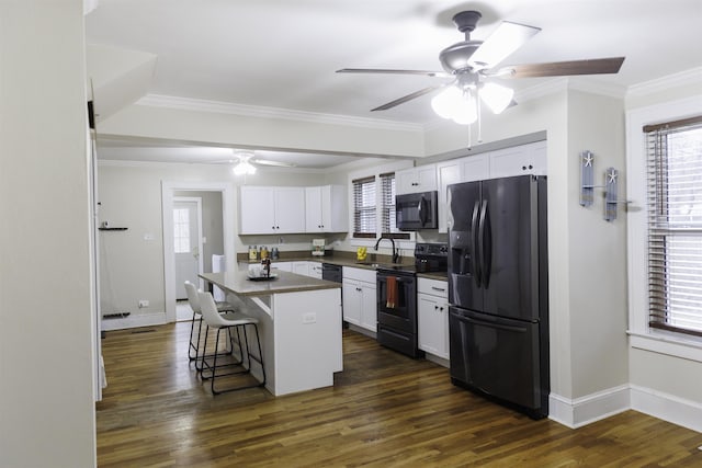 kitchen featuring sink, a breakfast bar, white cabinetry, stainless steel appliances, and a center island