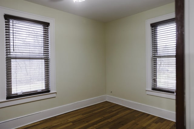 spare room featuring plenty of natural light and dark hardwood / wood-style floors