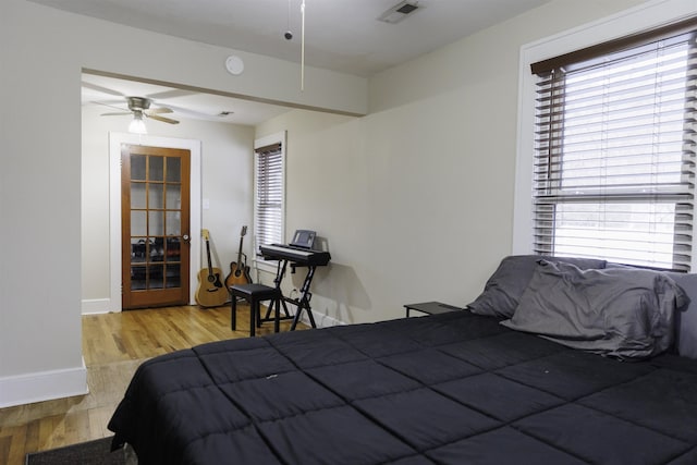 bedroom with multiple windows, ceiling fan, and light hardwood / wood-style flooring