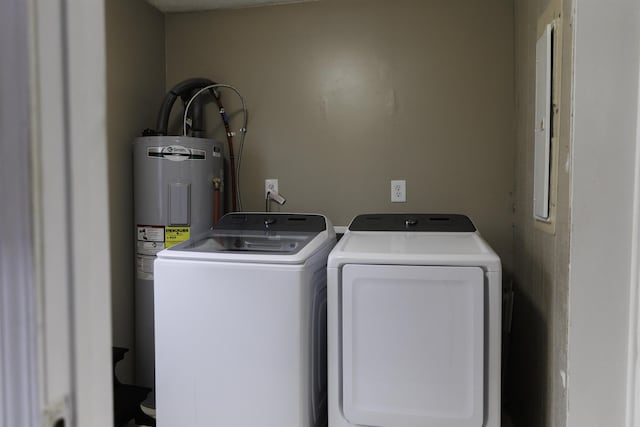 clothes washing area featuring electric water heater and independent washer and dryer