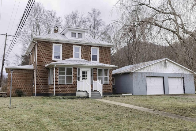 view of front of house featuring a garage, an outdoor structure, and a front lawn