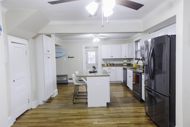 kitchen with white cabinetry, electric range, fridge, a center island, and a kitchen bar