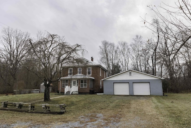 view of front of house with a garage, an outdoor structure, and a front lawn