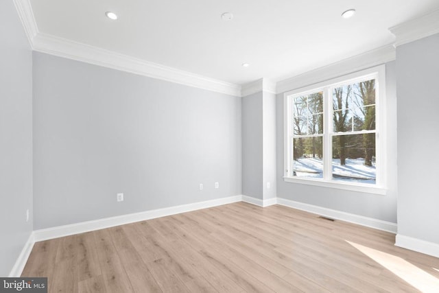 spare room featuring light hardwood / wood-style flooring and ornamental molding