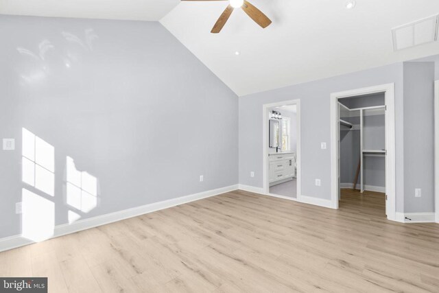 unfurnished room with vaulted ceiling and light wood-type flooring