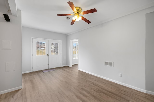 interior space with visible vents, baseboards, and wood finished floors