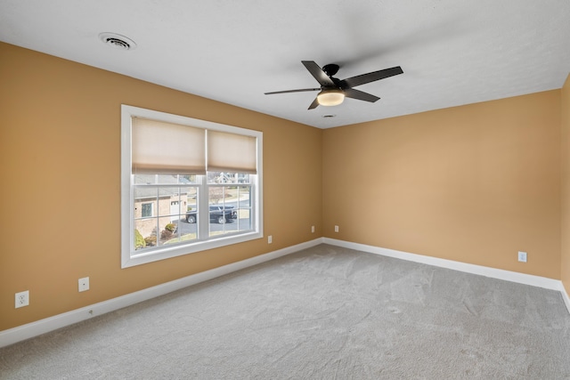 empty room with visible vents, a ceiling fan, baseboards, and carpet floors