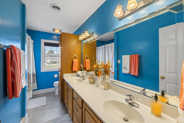 bathroom featuring visible vents, toilet, baseboards, and a sink