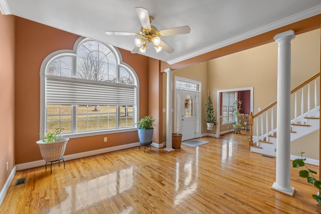 entrance foyer featuring stairway, wood finished floors, visible vents, ornate columns, and baseboards