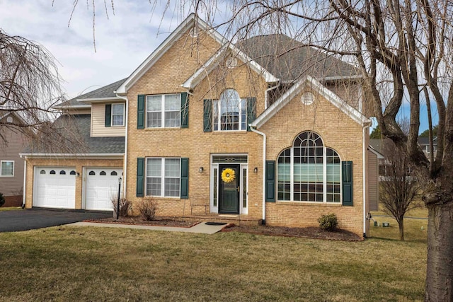 view of front of house featuring brick siding, driveway, and a front lawn