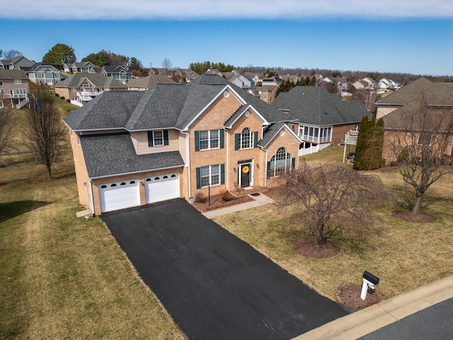 traditional-style home featuring aphalt driveway, brick siding, a residential view, and a shingled roof