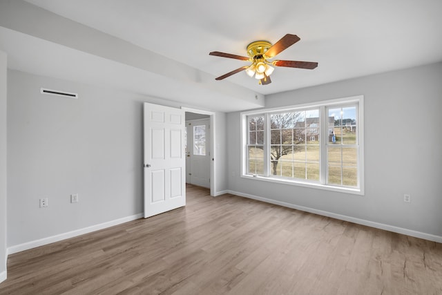 empty room with ceiling fan, baseboards, and wood finished floors