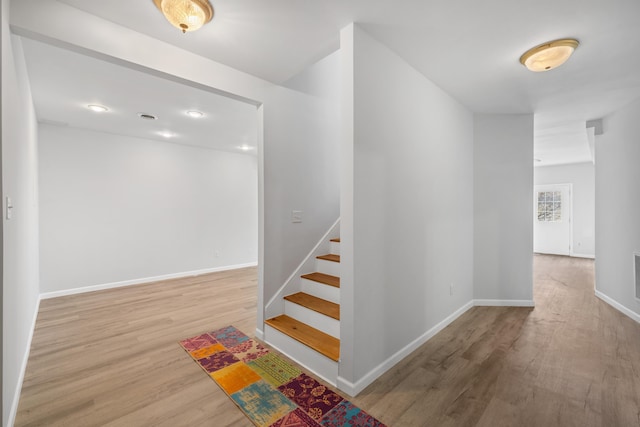 stairway featuring baseboards and wood finished floors