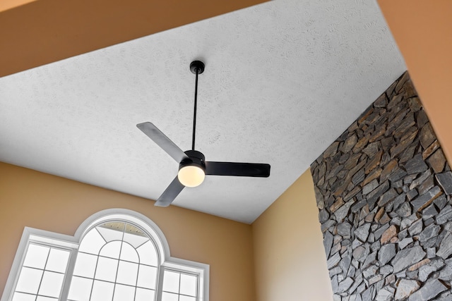 interior details with ceiling fan and a textured ceiling