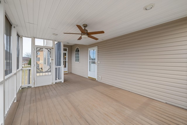 unfurnished sunroom featuring a ceiling fan