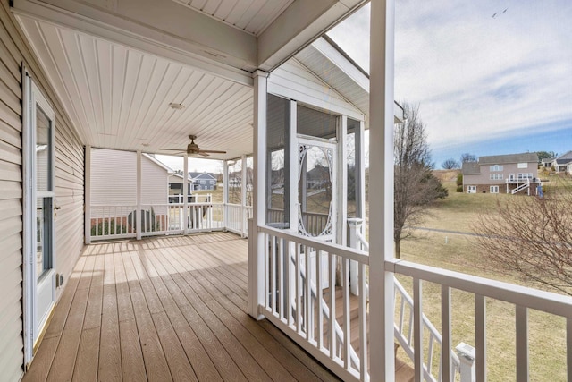 wooden terrace with a residential view, ceiling fan, and a sunroom