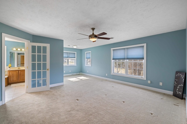 unfurnished room with baseboards, carpet, ceiling fan, and a textured ceiling