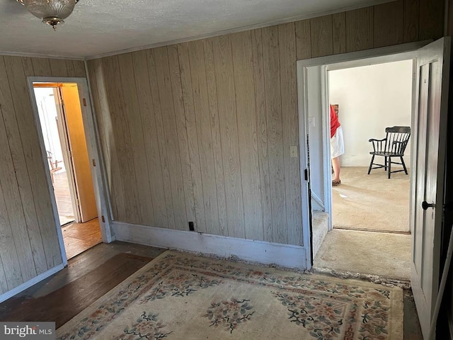 unfurnished room with crown molding and wood walls