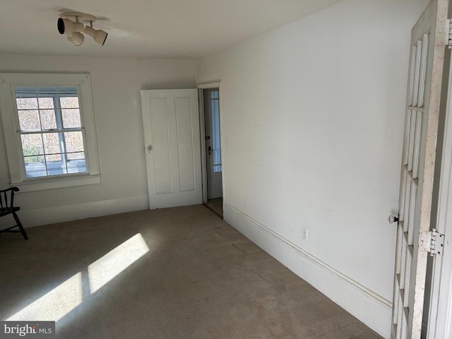 unfurnished room featuring dark colored carpet