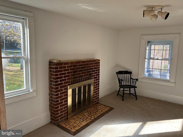 living area featuring plenty of natural light, carpet, and a fireplace