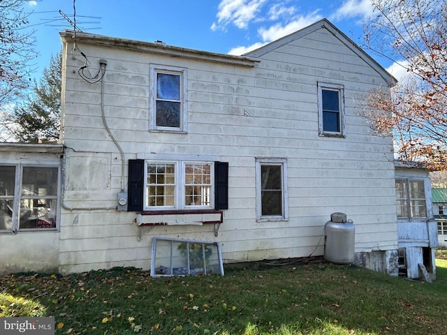 rear view of house with a lawn and a sunroom