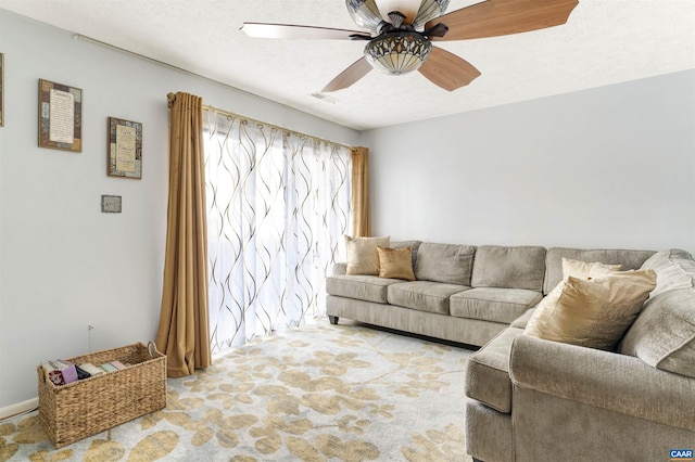 carpeted living room featuring a textured ceiling, visible vents, and a ceiling fan