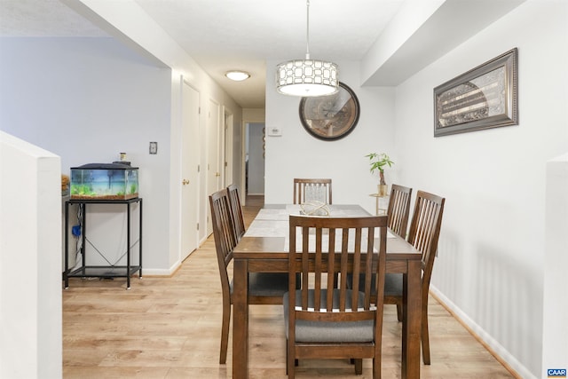 dining room with light wood finished floors and baseboards