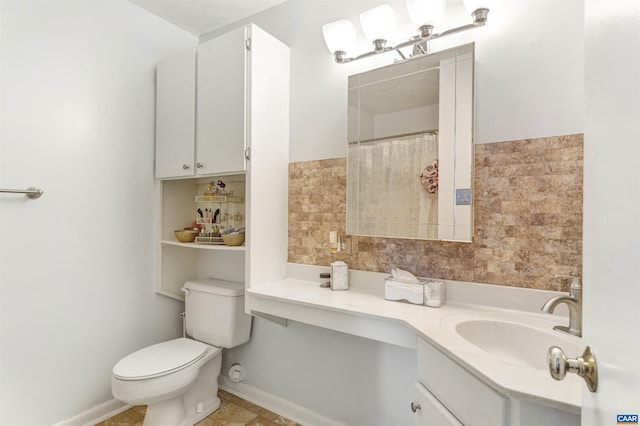 bathroom featuring baseboards, vanity, and toilet