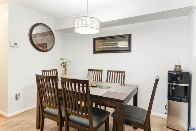 dining area with light wood-type flooring and baseboards