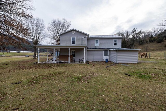 rear view of property with a lawn