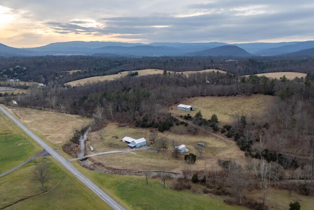 aerial view at dusk featuring a mountain view and a rural view