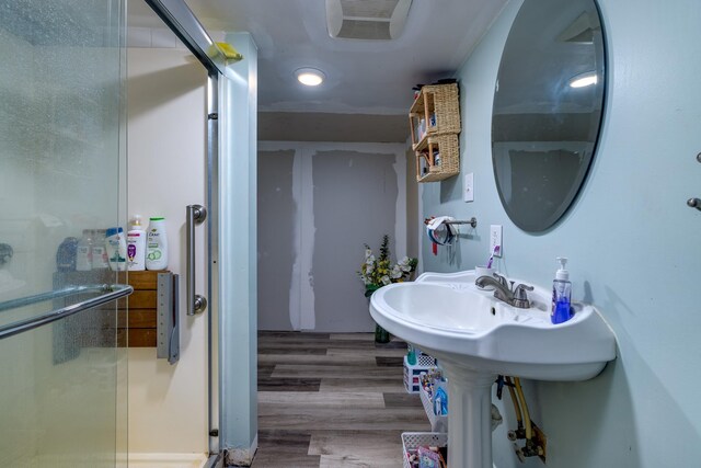 bathroom with hardwood / wood-style floors and an enclosed shower