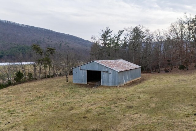 view of outdoor structure featuring a mountain view, a yard, and a rural view