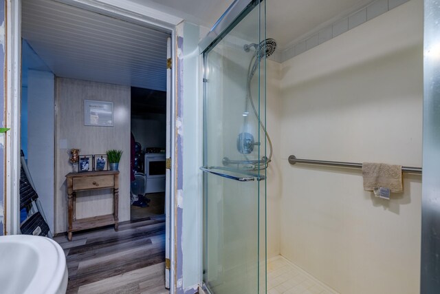 bathroom with wood-type flooring and an enclosed shower