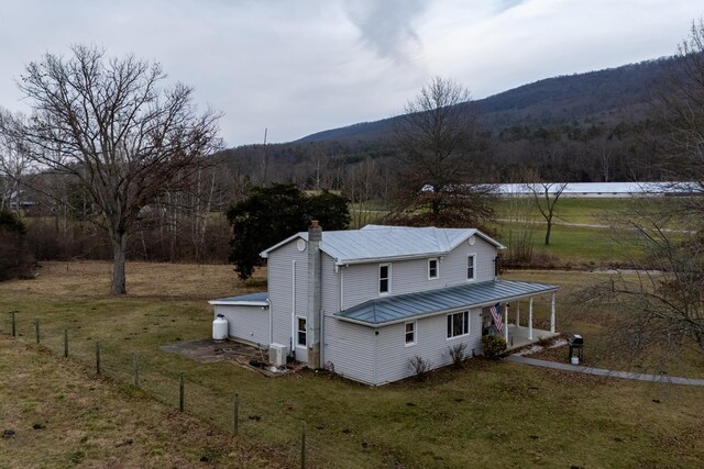 exterior space featuring a mountain view and a lawn