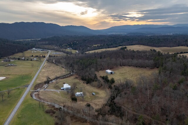 aerial view at dusk featuring a mountain view and a rural view