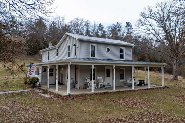 farmhouse inspired home with a porch and a front lawn