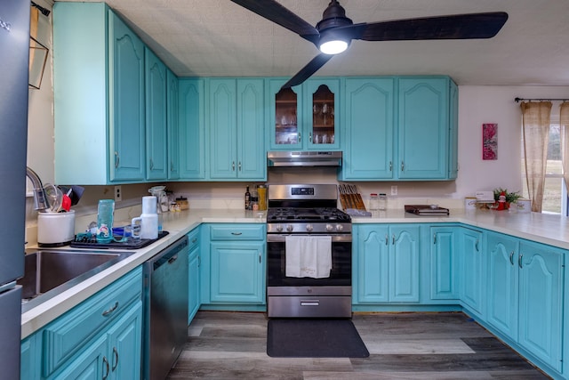 kitchen featuring stainless steel appliances, wood-type flooring, blue cabinetry, and ceiling fan