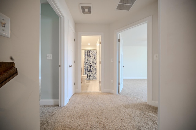 hall with light colored carpet