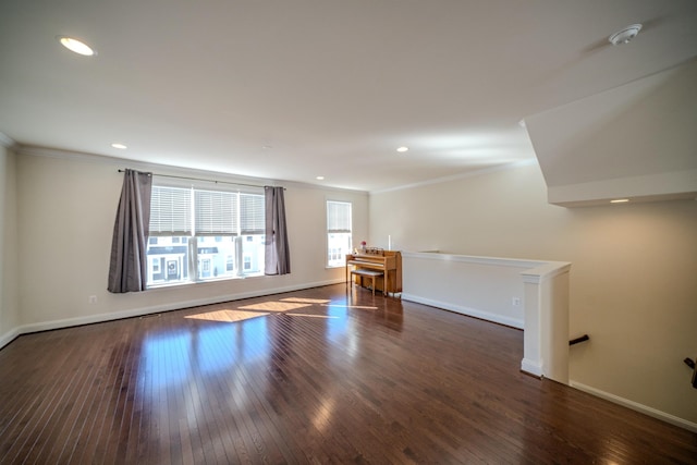 empty room with dark hardwood / wood-style flooring and crown molding